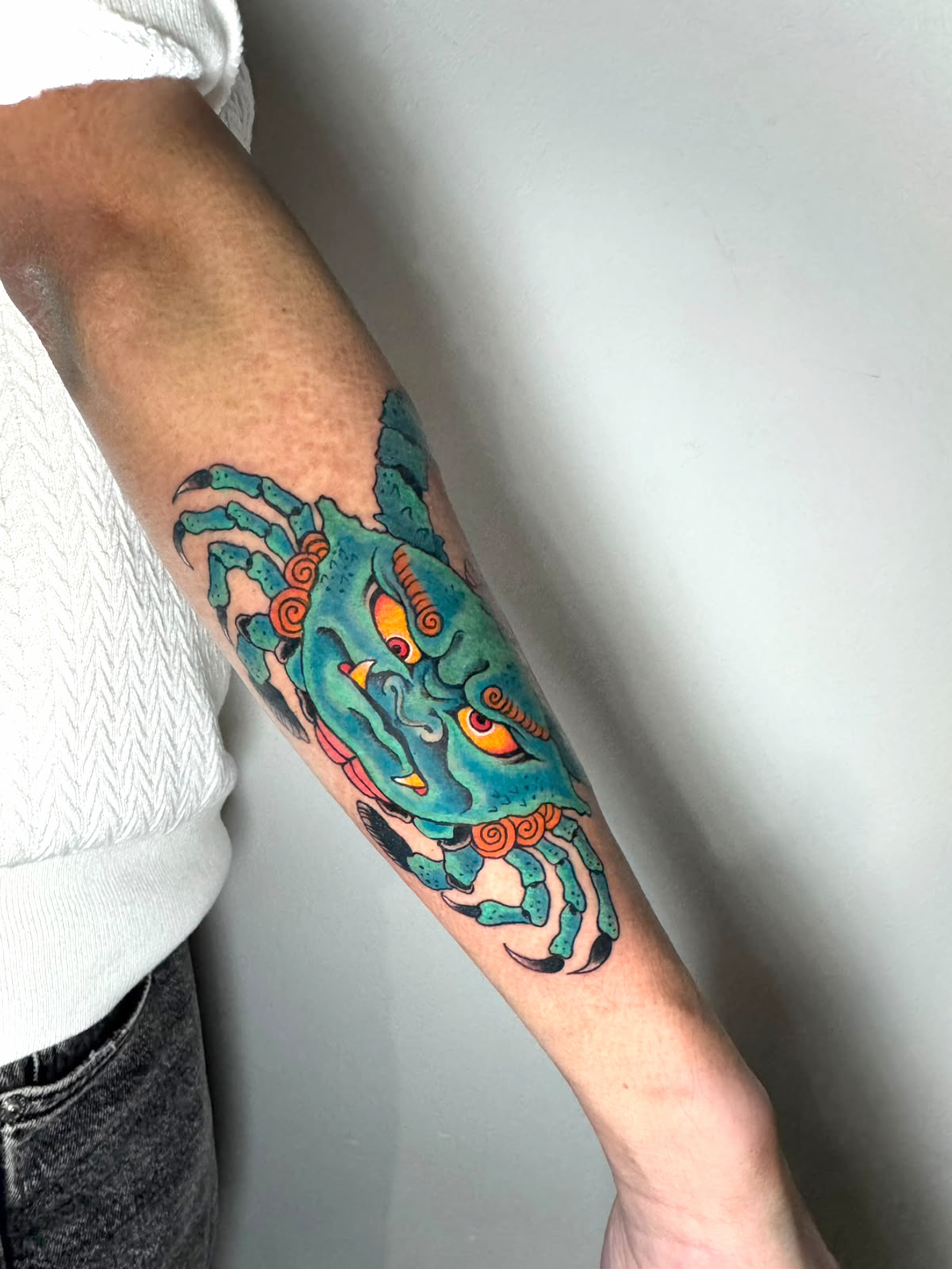 Tatuaggio a colori di un granchio in stile tradizionale.