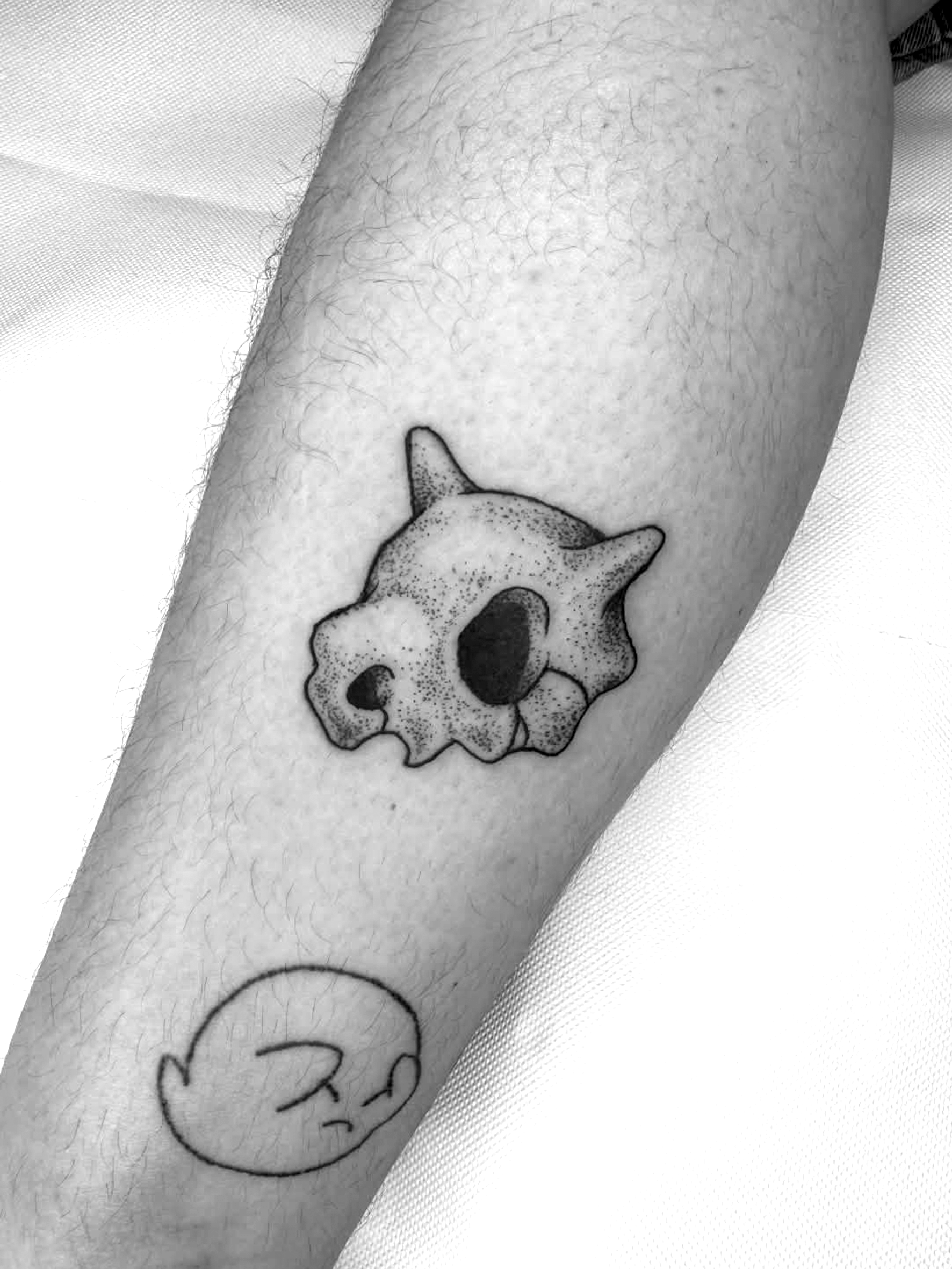 Piccolo tatuaggio in bianco e nero raffigurante un teschio.