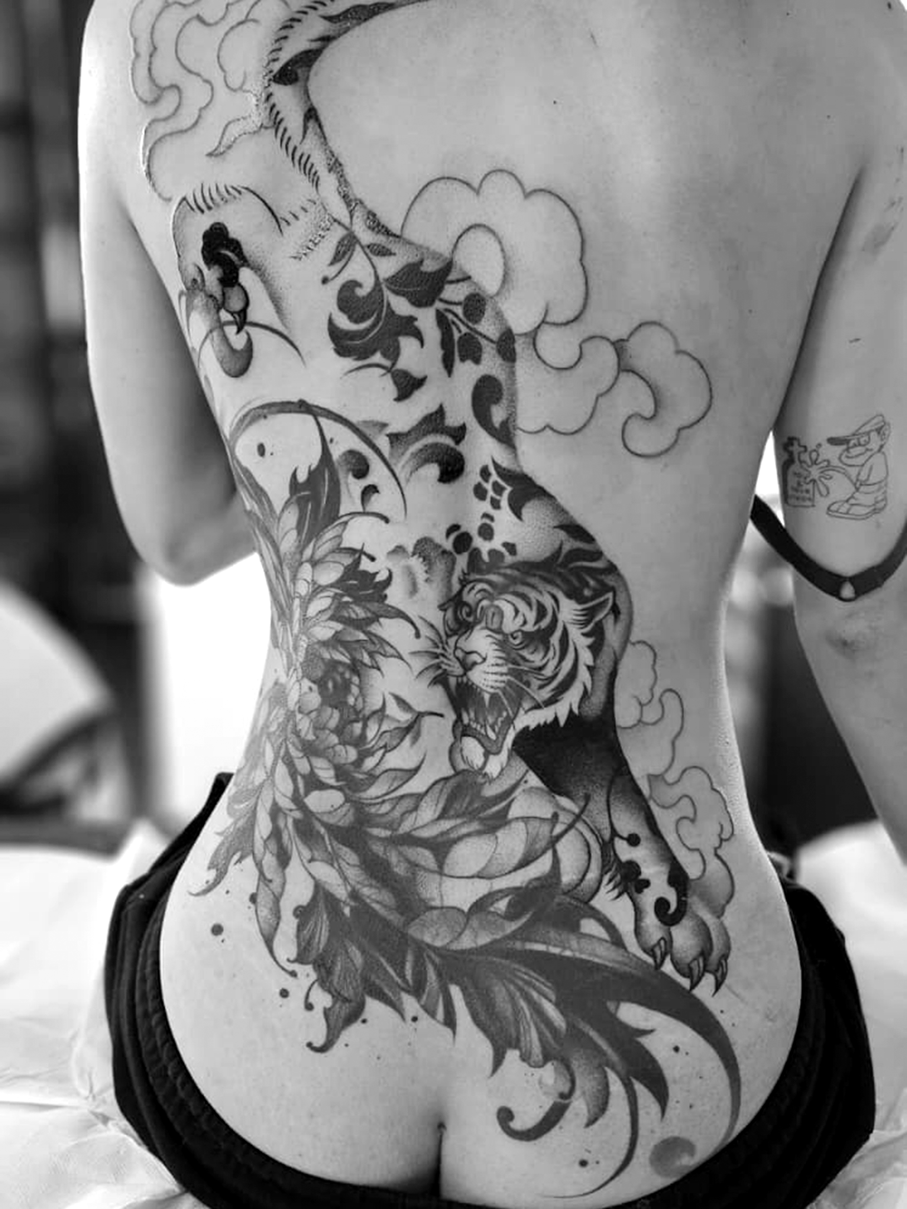 Grande tatuaggio in bianco e nero con tigre sulla schiena.
